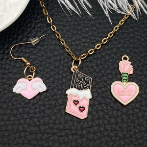 Pink heart pendants set with winged heart, chocolate bar, and LOVE rose charms