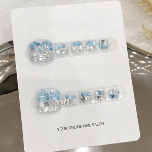 Handmade light blue and silver glitter press-on toenails on white card display