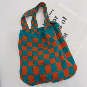 Close-up of orange and cyan blue checkered knitted tote bag with woven texture