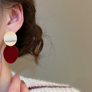 Gros plan d'un mannequin portant des boucles d'oreilles vintage en métal doré et velours