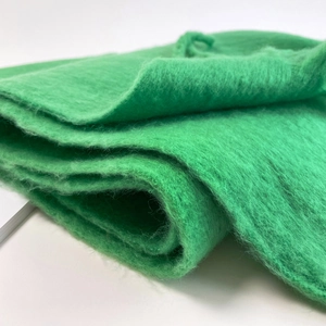 Close-up of bright green mohair scarf texture showing soft plush fabric and woven details