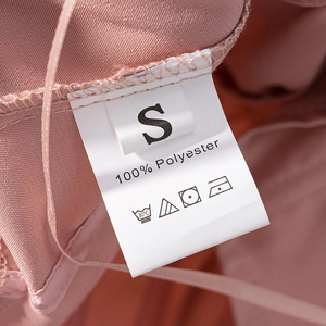 Detail of pink corset top care label showing size S and 100% polyester fabric content