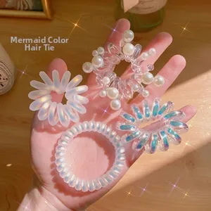 Close-up of four iridescent mermaid-colored spiral hair ties in various pearlescent finishes