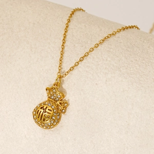 Macro d'un pendentif sac de fortune doré avec pavage de zircons et caractère chinois Fu ajouré