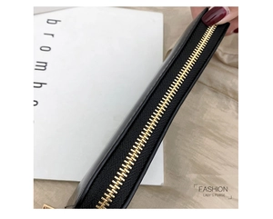 Nahaufnahme des goldenen Metallreißverschlusses an einer schwarzen Lederbrieftasche