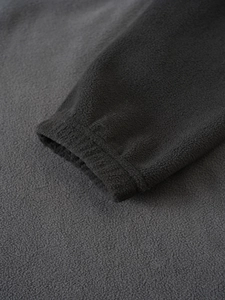 Close-up of high-quality dark grey polar fleece fabric and elastic cuff stitching
