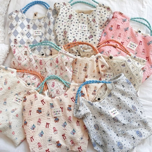 Close-up of pleated canvas tote bags with cute cartoon patterns and soft rope handles
