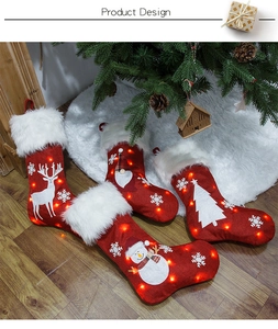 Detail showing red burlap Christmas stockings with LED lights on a wooden floor