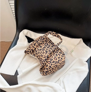 Sac à bandoulière tendance imprimé léopard posé sur une chemise blanche décontractée