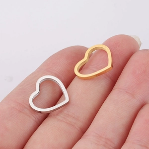 Close-up of gold and silver heart-shaped pendants showing high-polished mirror finish