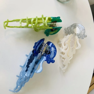 Three jellyfish-shaped acetate hair claws in green, blue gradient and sparkling white