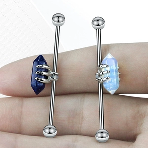 Vue macro d'un piercing industriel en acier avec des opales bleues serties par griffes