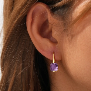 Close-up of elegant purple square gemstone earrings worn by model for a luxury style
