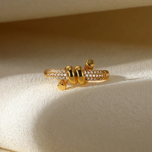 Close-up of gold-plated knot ring featuring pave-set sparkling zircon accents