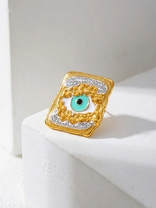 Macro shot of evil eye earring with turquoise enamel and crystals on stone stand