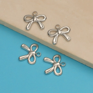 Macro detail of four silver titanium steel bow pendants with top rings on a dual-tone base