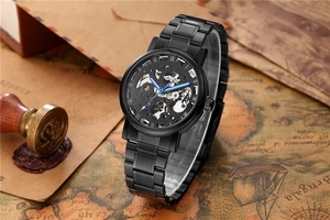 Détail d'une montre mécanique squelette noire avec aiguilles bleues sur carte du monde vintage