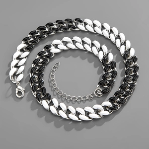 Detail of black and white Cuban chain with silver lobster clasp and glossy finish