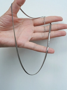 Detail of silver titanium flat snake bone chain with lobster clasp and adjustable tail