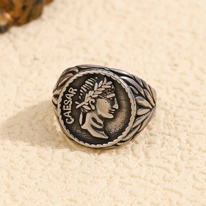 Macro shot of silver retro Roman coin ring featuring Caesar relief and engraved text