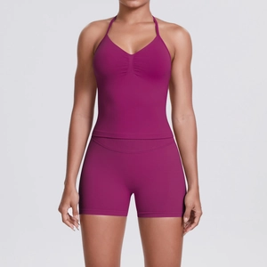 Detail of high-waisted dark rose yoga set with halter neck sports bra and peach lift shorts