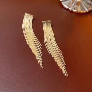 Elegant gold plated chain tassel drop earrings on a premium dark leather background