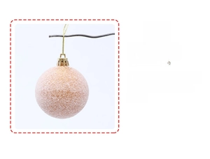 Detail of a frosted orange-pink Christmas ball with golden hanging loop and string