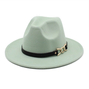 Detail of mint green fedora hat featuring black textured band and gold chain buckle accent