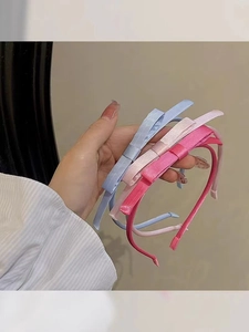 Detailed shot of pink and blue fabric bow headbands with sleek silk texture finish