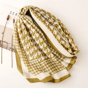 Flat lay of mustard green houndstooth scarf with aesthetic magazine and dried flowers