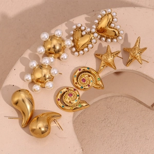 Flat lay of five pairs of 18K gold plated earrings with pearls and colorful zircons