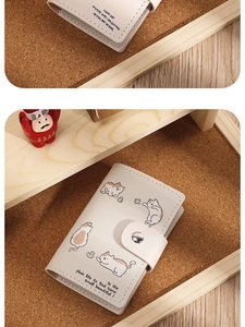 Close-up of cream card holder with cute cat illustration and secure snap button