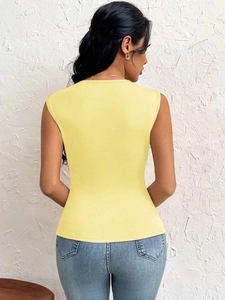 Elegant slim fit pale yellow sleeveless top showing the open back design and tailoring