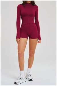 Detail of burgundy two-piece sports set with zippered top and high-waist side pocket shorts