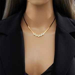 Gold flat snake chain necklace with five clear heart-shaped zircon pendants on model