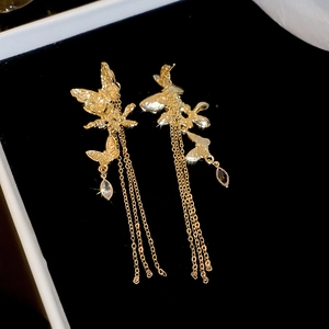 Detailed close-up of golden butterfly fringe earrings with shimmering zircon water drops