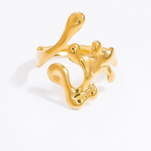 Close-up of golden stainless steel ring with an irregular abstract lava style design
