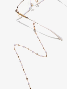 Detail of golden glasses chain with pearls and beads on eyeglass temples