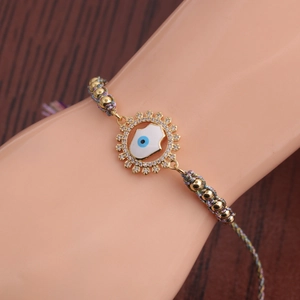 Détail macro du bracelet en cordon coloré tissé à la main avec breloque main de Fatima