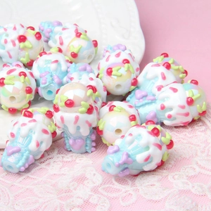 Macro shot of colorful resin ice cream beads on white lace for DIY jewelry making