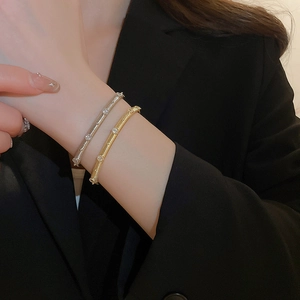 Detail of brushed gold and silver bangle set with tiny inlaid zircons on wrist
