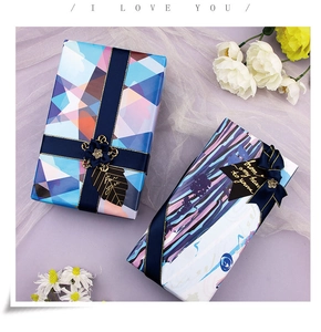 Detail of luxury gift wrap with navy blue ribbons, floral decor, and heart-shaped tags