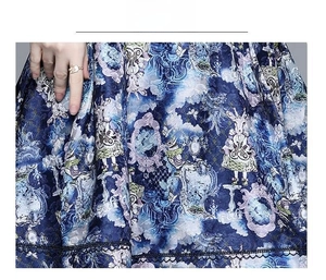 Close-up of blue dress fabric with vintage rabbit print and black hollow lace hem detail