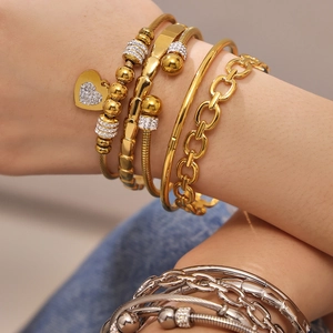 Conjunto de pulseras apilables de acero inoxidable dorado con detalle de colgante de corazón