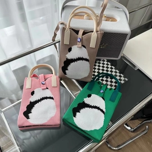 Détail de mini sacs en tricot avec motifs panda, boutons bijoux et bandoulières amovibles