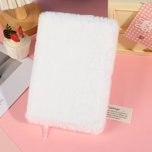 Minimalist white fuzzy plush A5 notebook on a cozy pink decorative desktop background