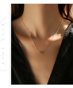 Gros plan d'un collier porte-bonheur en argent S925 doré porté au cou d'un mannequin
