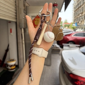 Detail of mini baseball keychain with wooden bat, leather glove, and braided rope strap