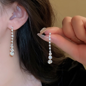 Ensemble de bijoux argentés avec boucles d'oreilles à pompons et collier sur un mannequin