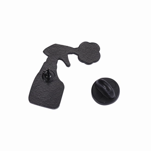 Macro detail of the matte textured metal back of a spray bottle enamel pin with rubber clutch